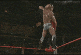 two men are wrestling in a wrestling ring .