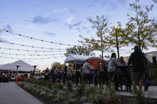 a group of people sitting at tables in a park