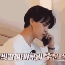 a man is talking on a cell phone in a room .