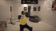 a person wearing a yellow jersey with the number 23 on it is playing a video game .