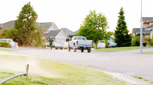 a white truck is parked on the side of the road in a residential neighborhood