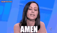 a woman is sitting in front of a blue background and saying amen .