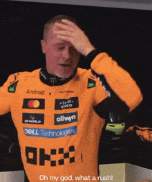 a man wearing an orange shirt with logos for dell technologies and allwyn