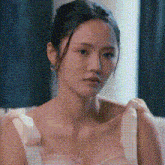 a woman in a white dress is sitting on a couch in a room .