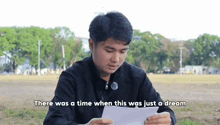 a man is holding a piece of paper with the words there was a time when this was just a dream written on it