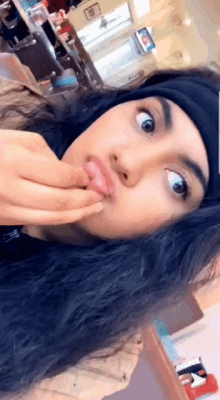 a woman is making a funny face with her hand on her mouth