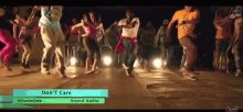 a group of people are dancing in front of a sign that says " don t care "