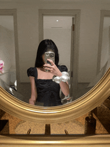 a woman taking a picture of herself in a mirror with the number 8 on her phone