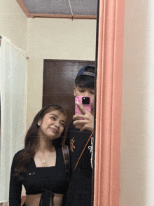 a man taking a picture of himself and a woman in a mirror