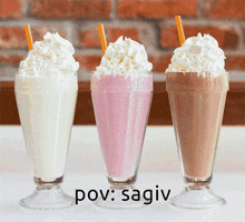 three milkshakes with whipped cream and orange straws are lined up next to each other with the caption pov : sativ