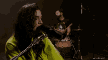 a woman singing into a microphone with a gif saying gifsdayrol at the bottom