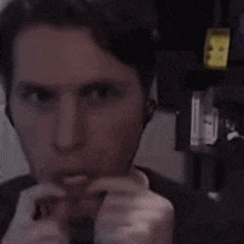 a man wearing ear buds is looking at the camera and making a funny face .