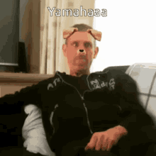 a man is sitting on a couch with a dog 's ears on his face and the caption yamahaaa