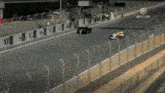 a race track with a fence and a sign that says motors in the corner