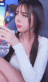 a woman with pigtails is drinking a glass of water .