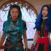 a woman with blue hair stands next to another woman with green hair