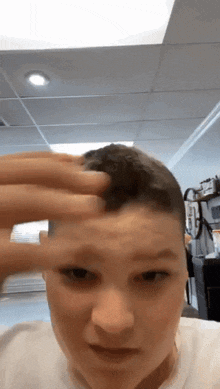 a young boy is scratching his forehead with his finger