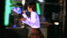 a blurry picture of a woman singing into a microphone in a dark room