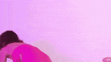 a woman in a pink dress is doing a yoga pose in front of a mirror with a picture of her face on it .