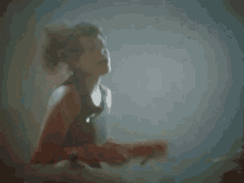 a woman is playing drums in a dark room .