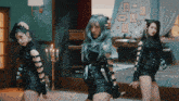 three women are dancing in a room with candles on the wall