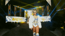 a woman in a white fur coat is standing in front of a banner that says bayne