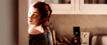 a woman is standing in a kitchen with her hair in a ponytail