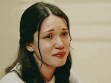 a woman with long hair is crying with her eyes closed