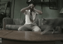 a man sitting on a couch with his hands on his head