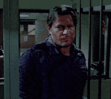 a man with blood on his face behind bars