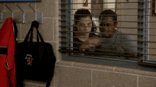a boy and a girl look out a window with chicago written on a black bag