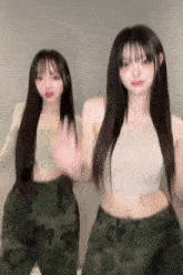a couple of girls are standing next to each other in a room .