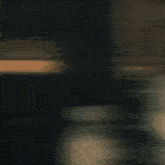 a blurry picture of a woman sitting on a couch in a dark room