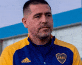 a man wearing a blue and yellow cabj shirt
