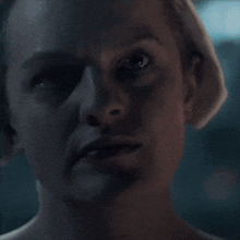 a close up of a woman 's face with a serious look on her face