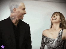 a man and a woman are laughing with a purple star in the corner
