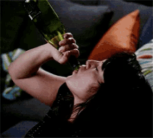 a woman is drinking from a bottle with a label that says ' jameson '