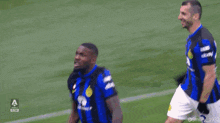 a group of soccer players are playing on a field with a yellow banner that says item on it