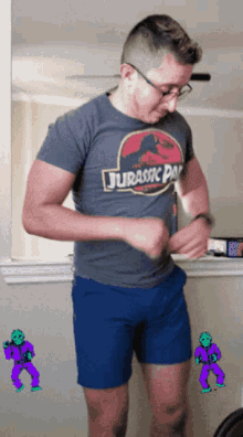 a man is wearing a jurassic park shirt