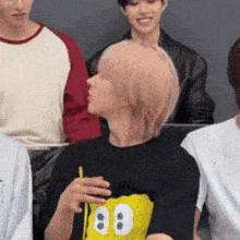 a group of people are sitting in a room and one of them is wearing a mickey mouse shirt with the number 88 on it