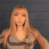 a woman with long blonde hair is wearing a sweater with a leopard print