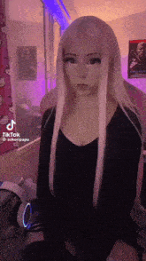 a woman with long blonde hair is wearing headphones and a black shirt .