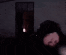 a man with a beard is holding his head with his hands in a dark room .