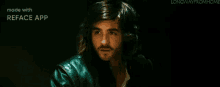 a man with long hair is wearing a green leather jacket .