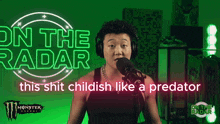 a man wearing headphones and a monster energy shirt is talking into a microphone
