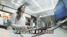 a woman is typing on a keyboard in an office with a tv twice logo above her