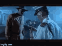 a man in a hat is talking to a police officer in a dark room