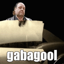 a man is holding a piece of paper with the word gabagool on it