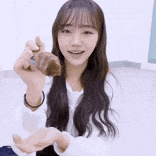 a girl with long hair is holding a piece of chocolate in her hands