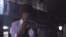 a man in a white shirt and black tie is holding a piece of paper